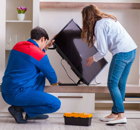 Repairman repairing tv at homeの写真素材