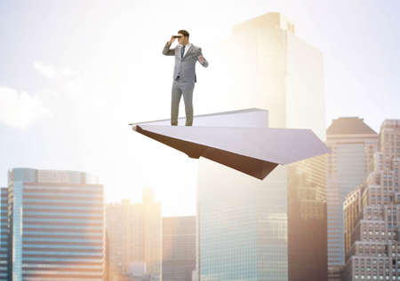 Businessman flying on paper plane in business conceptの写真素材