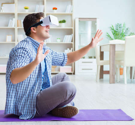 Man wearing virtual reality VR glasses doing sports at home
