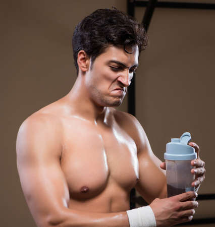 Man with nutrient supplements in sports gymの写真素材