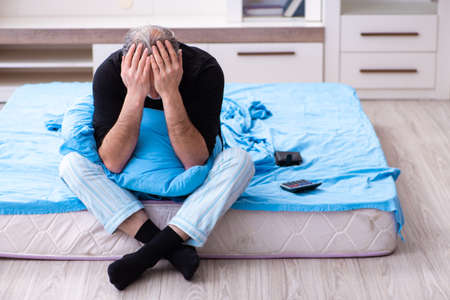 Unhappy old man in the bedroomの写真素材