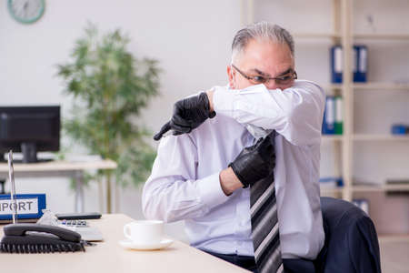 Old male boss employee working during pandemicの写真素材