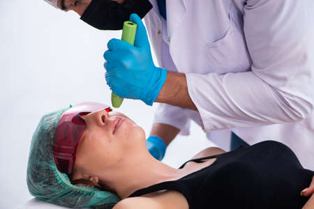 Young woman visiting male doctor dermatologistの写真素材