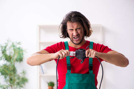 Funny young male electrician working indoorsの写真素材