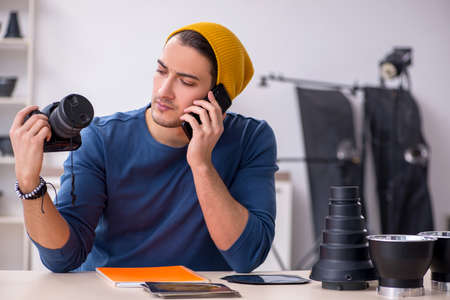 Young male photographer working in the studio
