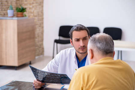 Old patient visiting young male doctor radiologistの写真素材