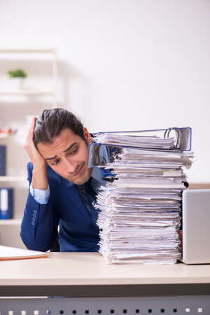 Young male employee unhappy with excessive workの写真素材