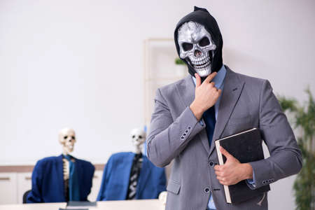 Funny business meeting with devil and skeletonsの写真素材