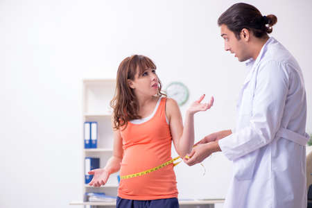 Pregnant woman visiting male doctor gynecologistの写真素材
