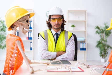 Funny construction business meeting with boss and skeletons