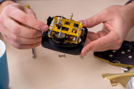 Young male watchmaker working in the workshop