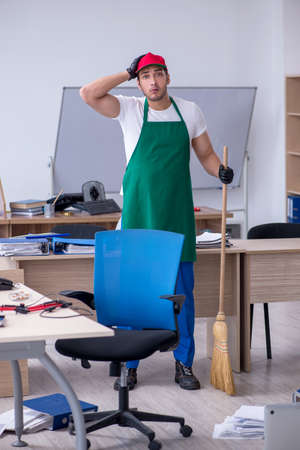 Young male contractor cleaning the officeの写真素材