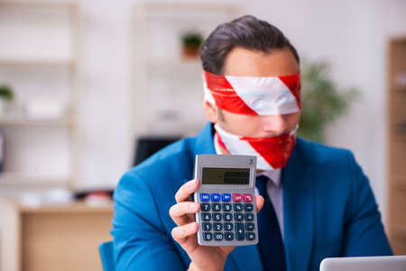 Mouth and eyes closed male employee working in the officeの写真素材