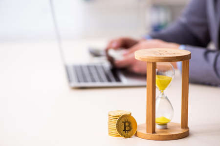 Young man earning money via Internet in time management conceptの写真素材