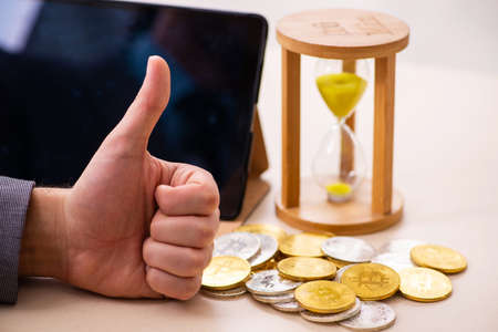 Young man earning money via Internet in time management conceptの写真素材