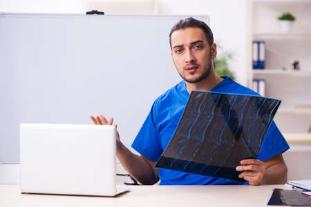 Young male doctor teacher radiologist in front of whiteboard