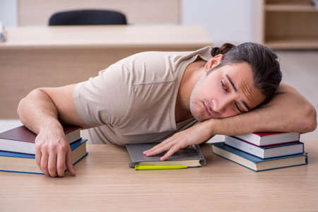 Young male student preparing for exams at libraryの写真素材