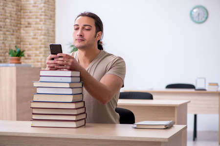 Young male student preparing for exams at libraryの写真素材