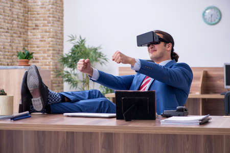 Young male employee wearing virtual glasses in the office