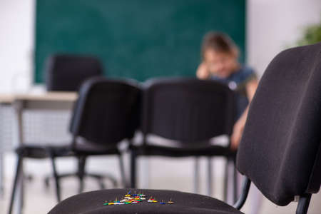 Secondary school prank with sharp thumbtacks on chairの写真素材