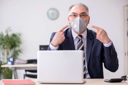 Old male boss employee working during pandemicの写真素材