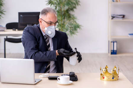 Old male boss employee working during pandemicの写真素材