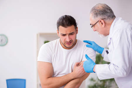 Young man visiting experienced doctor dermatologistの写真素材