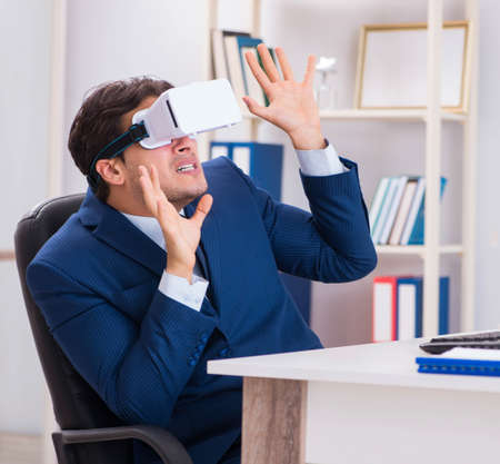 Employee using virtual reality glasses in officeの写真素材
