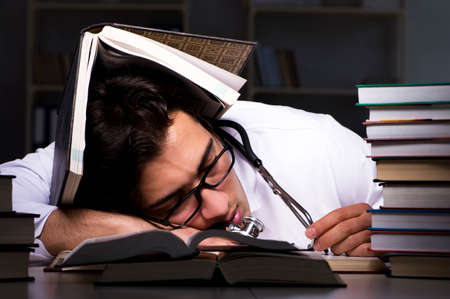 Medical student preparing for university exams at nightの写真素材