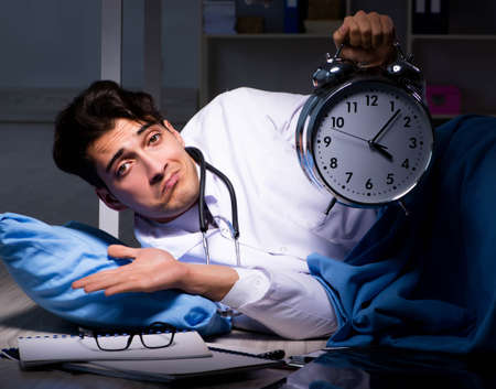 Doctor working night shift in hospital after long hoursの写真素材