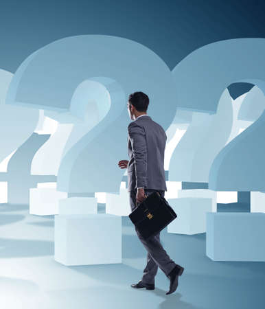 Businessman in uncertainty concept with question marksの写真素材