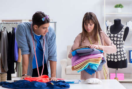 Male tailor with female student in workshopの写真素材