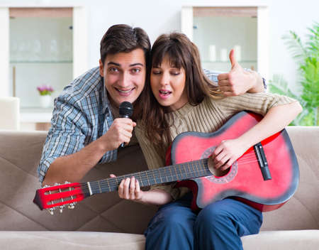 Young family singing and playing music at homeの写真素材
