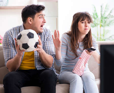 Family pair watching football at homeの写真素材