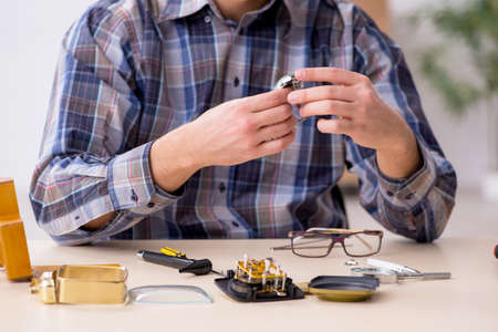 Young male watchmaker working in the workshopの写真素材