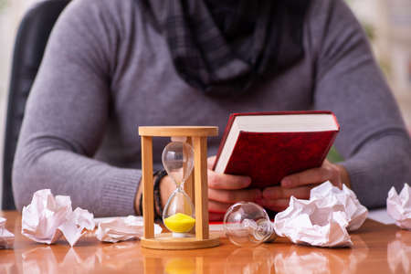 Young male writer in time management concept