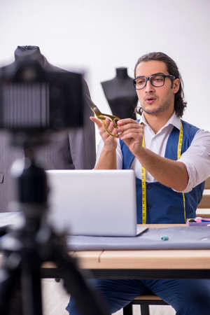 Young male tailor recording video for his blogの写真素材