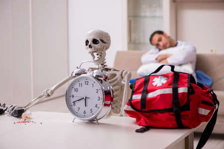 Young male paramedic visiting skeleton patientの写真素材