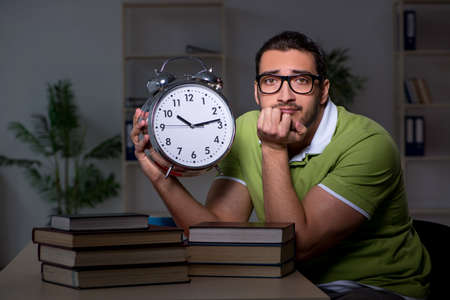 Young student studying at night at homeの写真素材