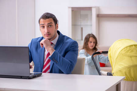 Young divorced father of two children working from houseの写真素材