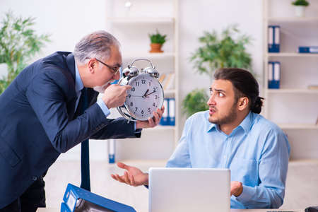 Old boss and his young assistant in the officeの写真素材