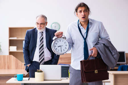 Old boss and his male secretary employee in time management concの写真素材