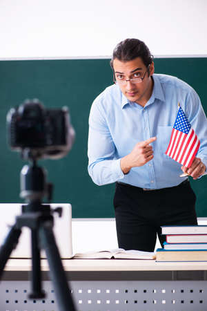 Young handsome teacher recording video for his blogの写真素材