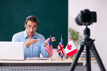 Young handsome teacher recording video for his blogの写真素材