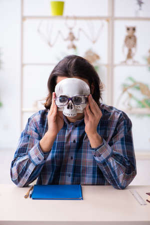 Young male teacher paleontologist in the classroomの写真素材