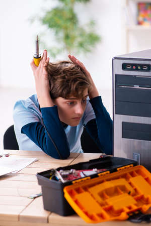 Boy reparing computers at workshopの写真素材