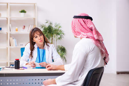 Young arab businessman visiting caucasian female doctorの写真素材