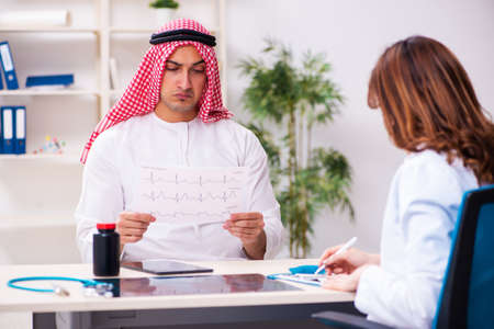 Young arab businessman visiting caucasian female doctorの写真素材