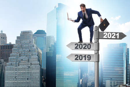 Road sign and businessman with 2020 and 2021の写真素材