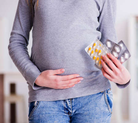 Pregnant woman taking pills during pregnancyの写真素材
